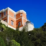 Il Faro di Capo d’Orso visto dal basso, tra la vegetazione della scogliera