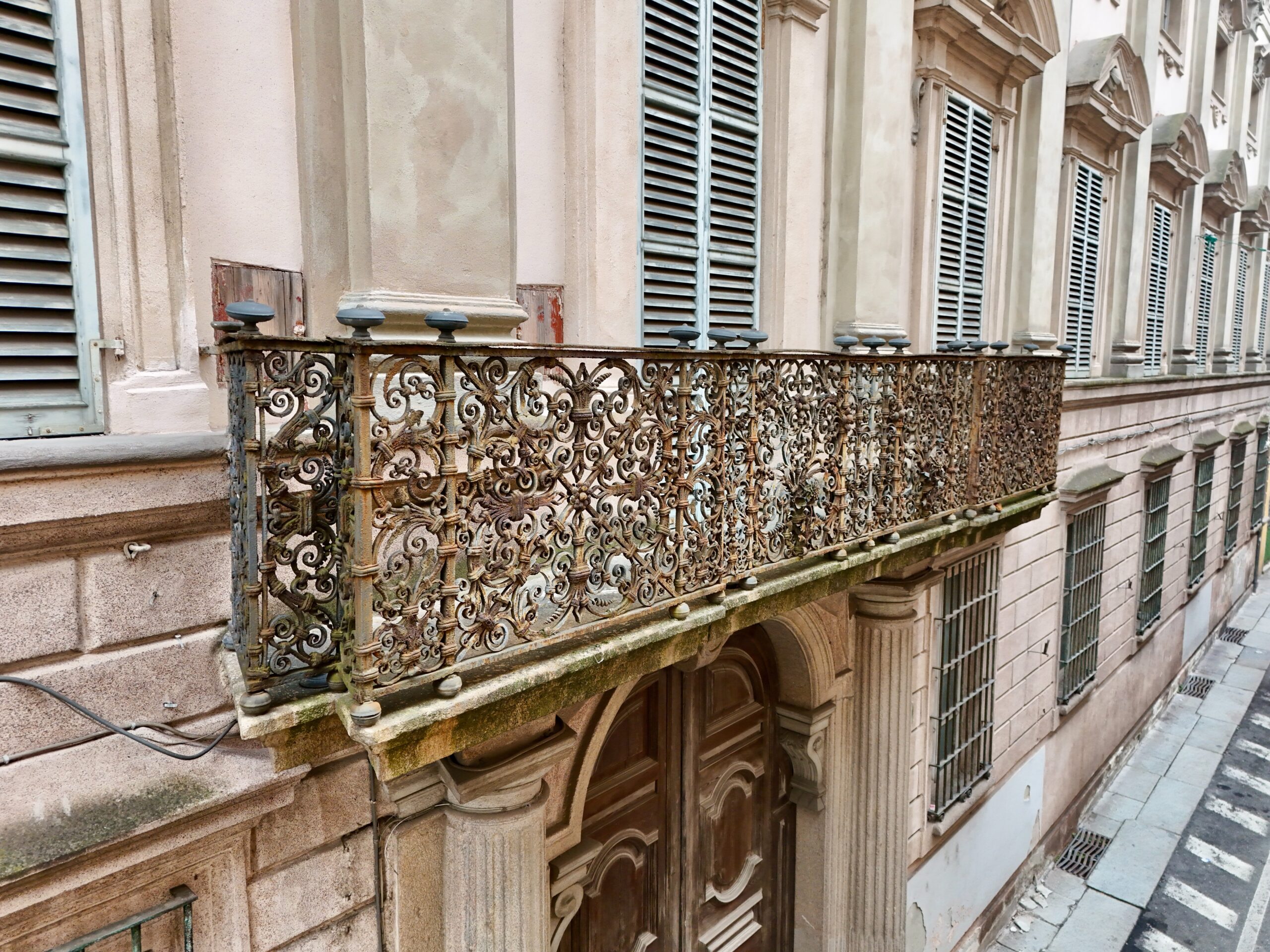 Il balcone in ferro battuto sopra il portone di Palazzo Costa Ferrari