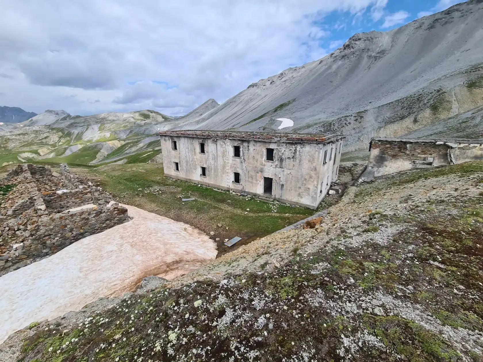L'ex casermetta della Forcola del Braulio fra le montagne dell'Alta Valtellina, con la neve sul pendio