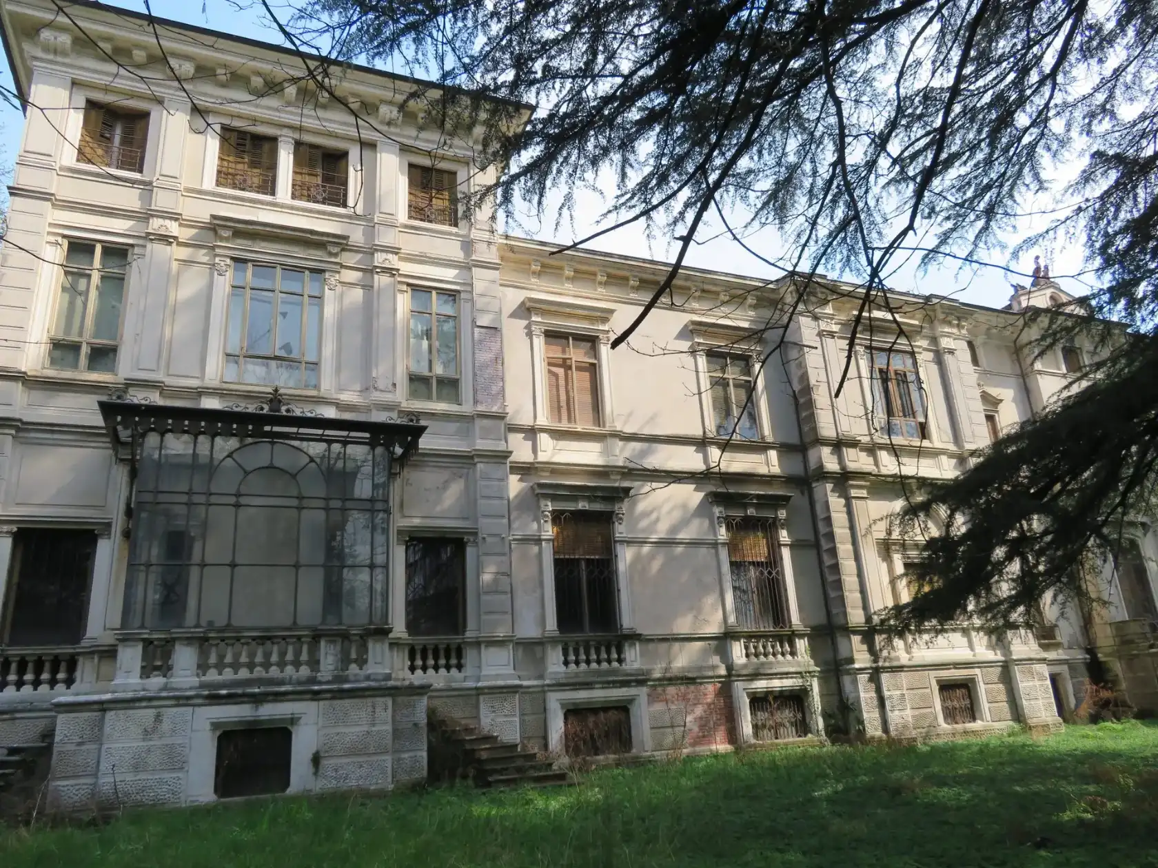 La facciata di Villino Rossi a Schio, con la serra in ferro e vetro e gli alberi del parco
