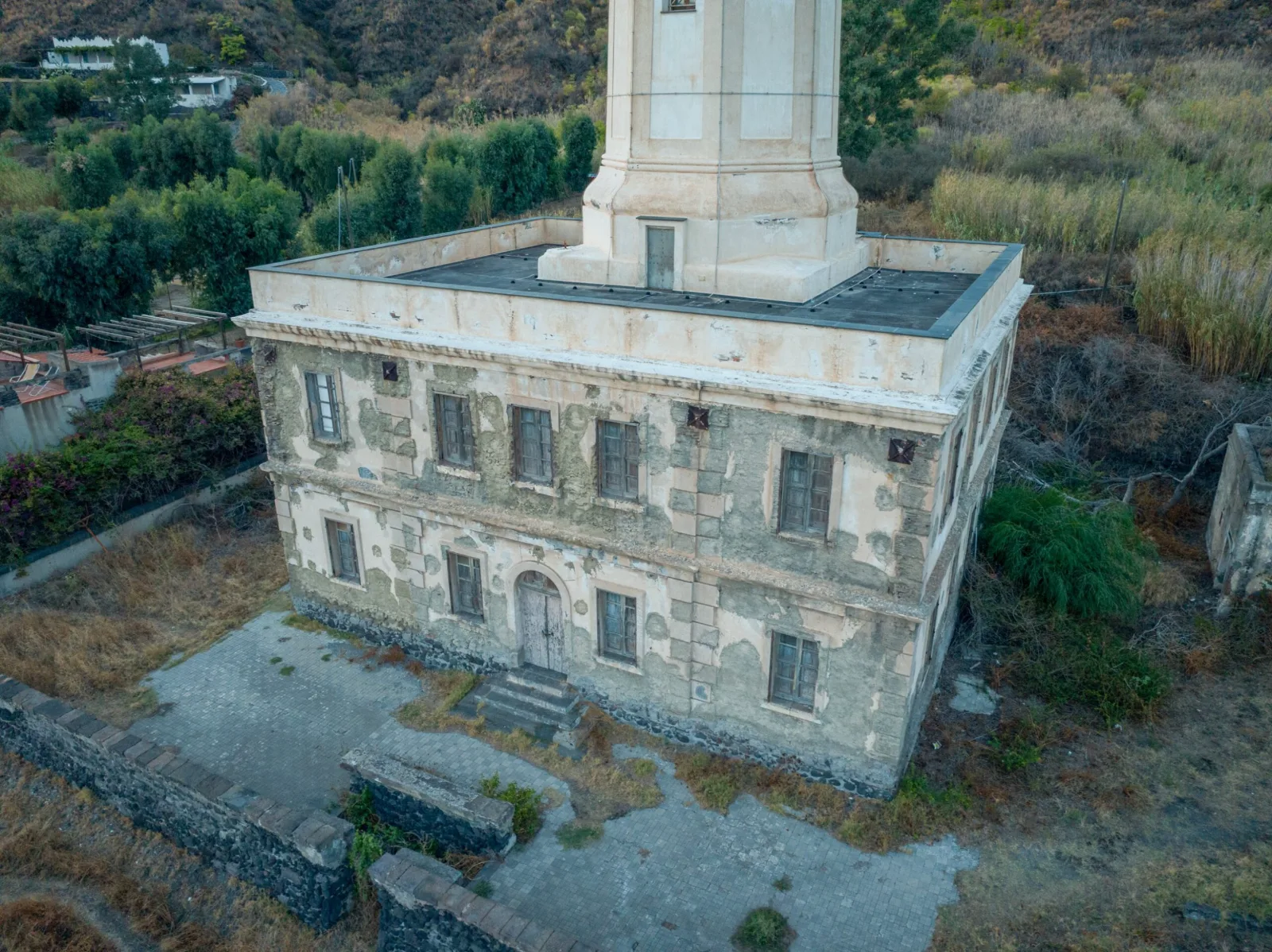 Un faro dello Stato visto dall'alto, con tetto piano e vegetazione intorno