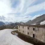 La casermetta in quota fra i nevai, con le montagne sullo sfondo