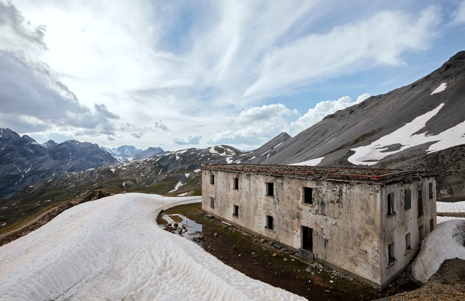 La casermetta in quota fra i nevai, con le montagne sullo sfondo