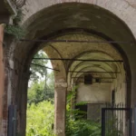 L’androne ad arco con le volte in mattoni e la vegetazione