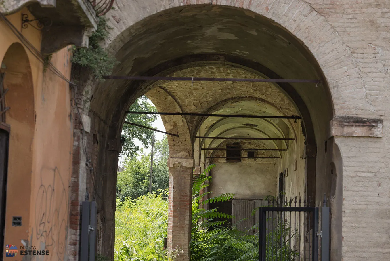 L’androne ad arco con le volte in mattoni e la vegetazione