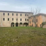 La facciata con il portico a quattro archi, vista dal prato