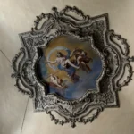Un soffitto con medaglione affrescato e cornice in stucco
