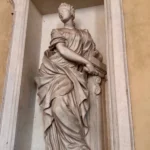 Una statua femminile in una nicchia dello scalone