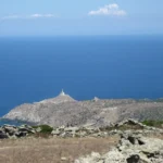 Il faro con la torre e il corpo in pietra all'estremità dell'isola