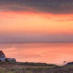 Il faro acceso al tramonto sul mare