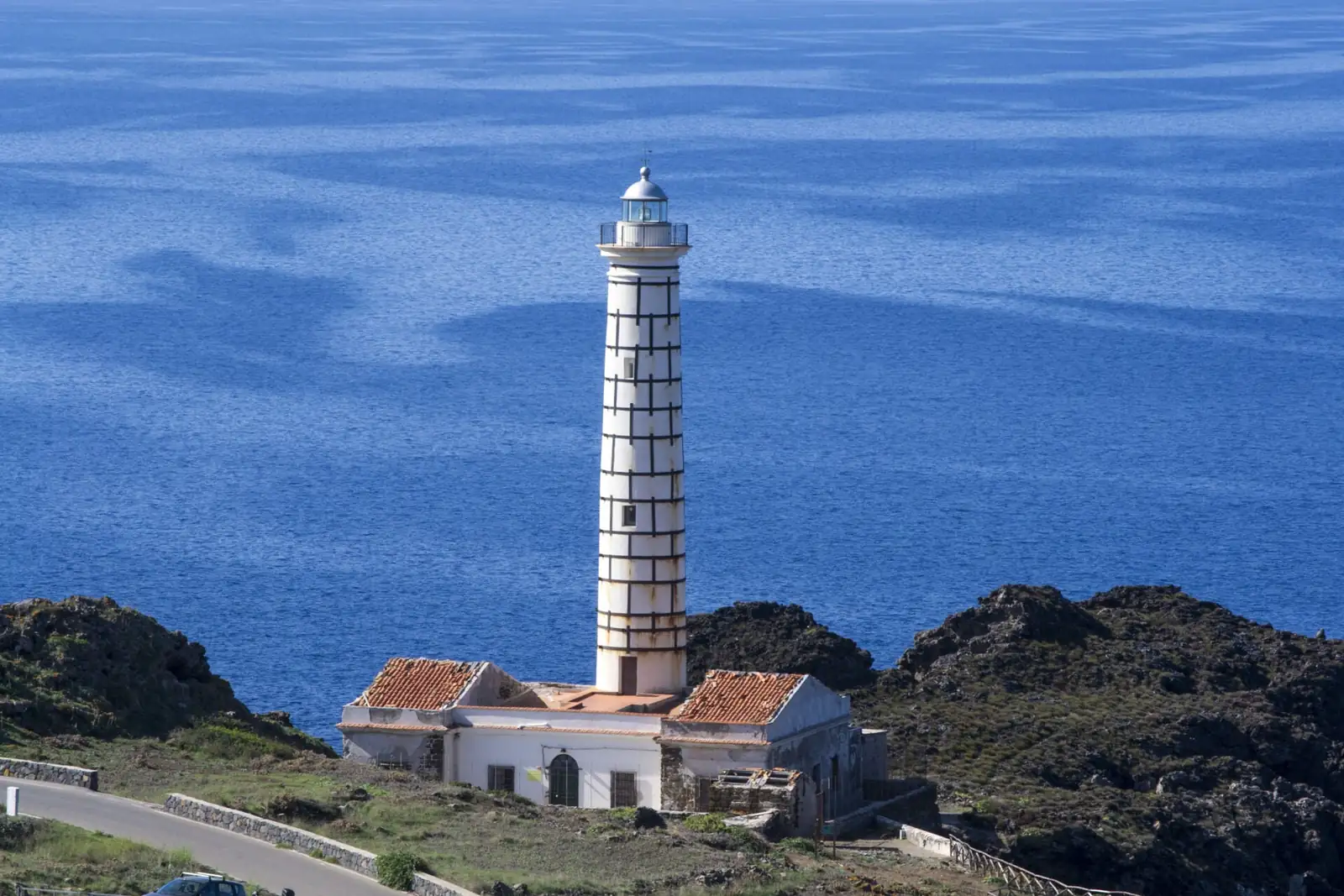 Il faro e gli alloggi visti dall’alto, con il mare blu