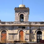 La facciata frontale del vecchio faro con la torretta merlata
