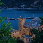 La Torre Capitolare e il porto all’ora blu, visti fra gli alberi