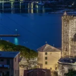 La Torre Capitolare all’ora blu, con il golfo e le luci della costa