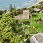 La torre fra i pini e i prati, vista dall’alto con la costa